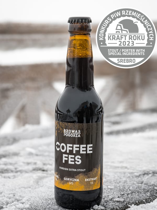 Butelka Coffee Fes na zaśnieżonej balustradzie, obok odznaka srebrnego medalu Kraft Roku 2023